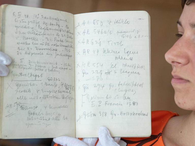 Frederike Uhl, wissenschaftliche Hilfskraft im Posse-Editions-Projekt im Germanischen Nationalmuseum, hält ein original Diensttagebuch von Hans Posse.