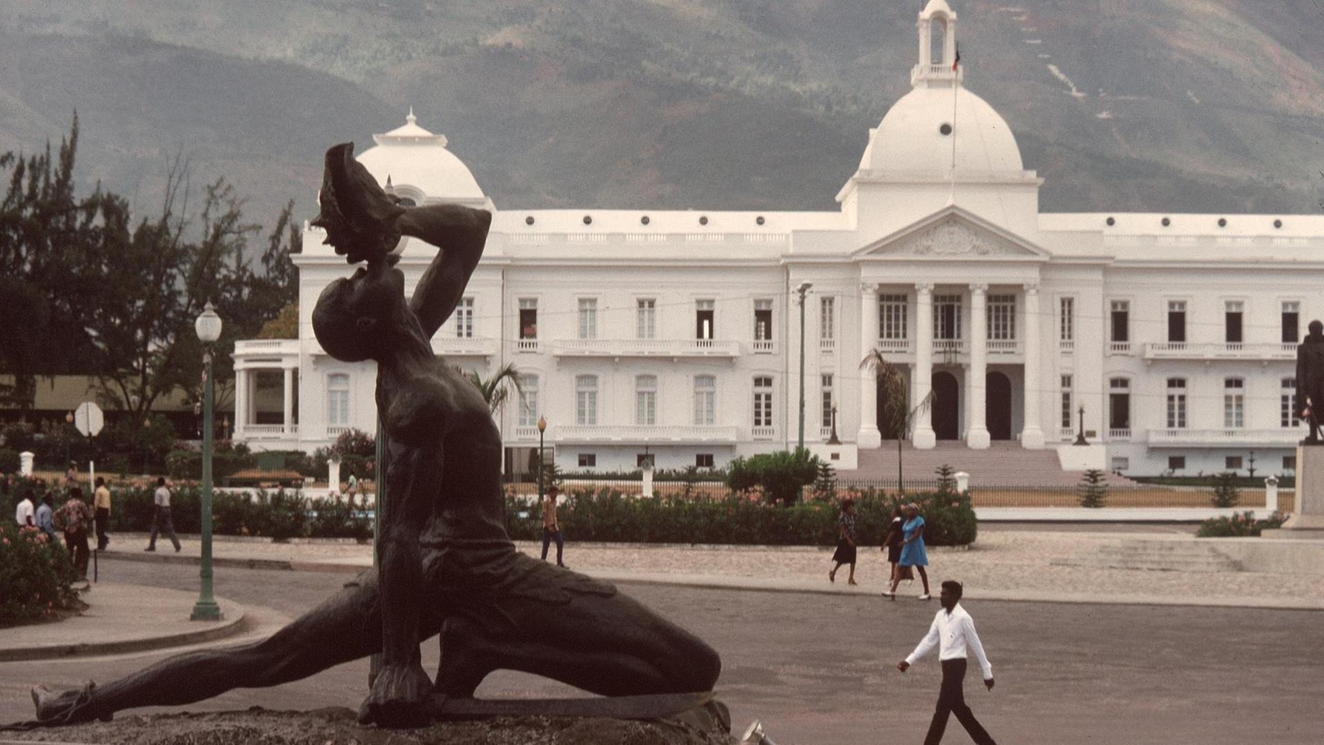 Der Präsidentenpalast in der haitianischen Hauptstadt Port-au-Prince und davor das Mahnmal "Negre Marron". Es zeigt einen Schwarzen, der in eine Muschel bläst und den Ruf an alle Brüder seiner Rasse richtet, die sich nicht mehr der Sklaverei unterwerfen wollen. Der Präsidentenpalast in der haitianischen Hauptstadt Port-au-Prince und davor das Mahnmal "Negre Marron". Es zeigt einen Schwarzen, der in eine Muschel bläst und den Ruf an alle Brüder seiner Rasse richtet, die sich nicht mehr der Sklaverei unterwerfen wollen.