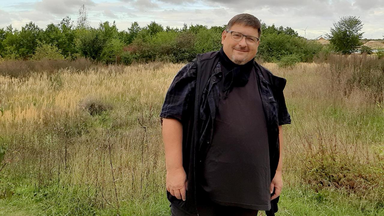 Peter Feine steht vor einer Wiese und schaut freundlich in die Kamera Peter Feine steht vor einer Wiese und schaut freundlich in die Kamera
