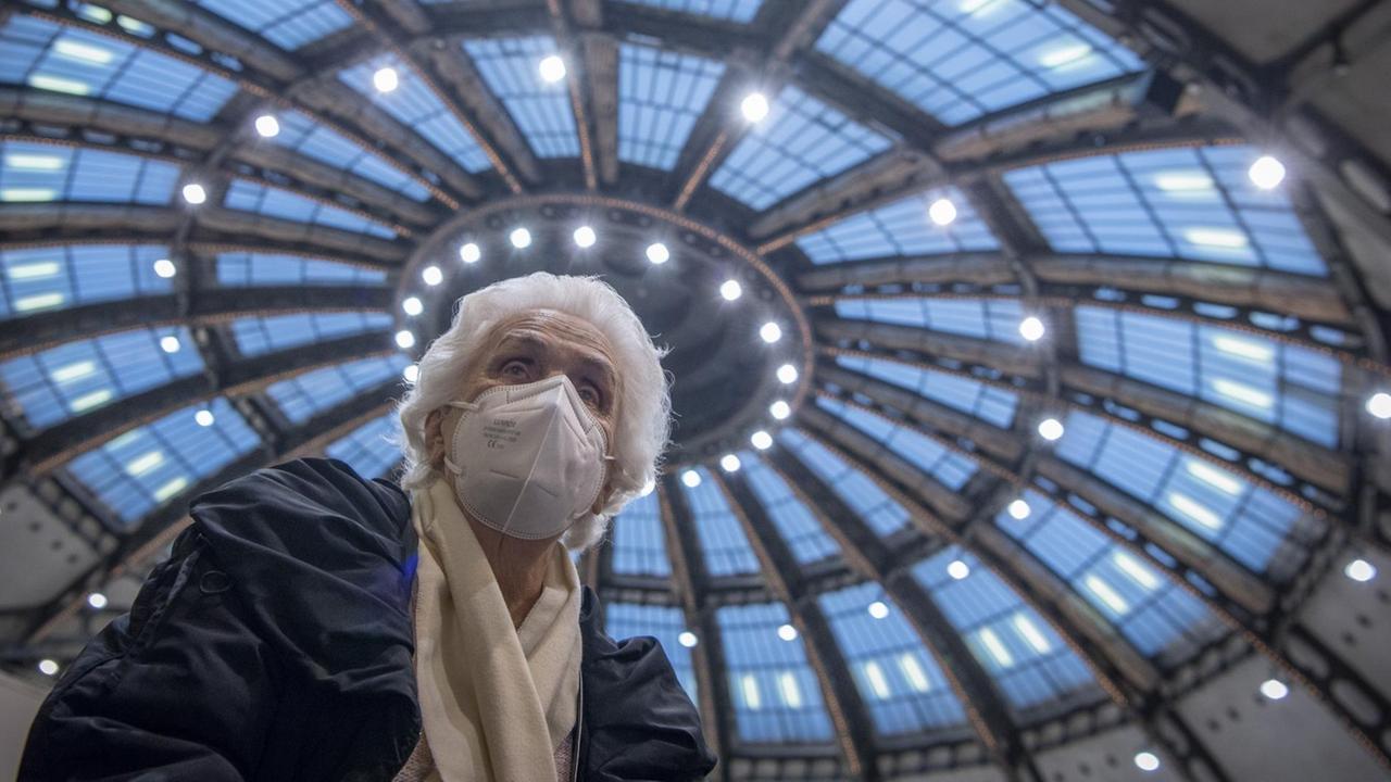 Nachdem sie ihre Impfung gegen das neuartige Coronavirus erhalten hat, sitzt die 90-jährige Odores H. unter dem Kuppeldach des Impfzentrums in der Festhalle in Frankfurt. Nachdem sie ihre Impfung gegen das neuartige Coronavirus erhalten hat, sitzt die 90-jährige Odores H. unter dem Kuppeldach des Impfzentrums in der Festhalle in Frankfurt.