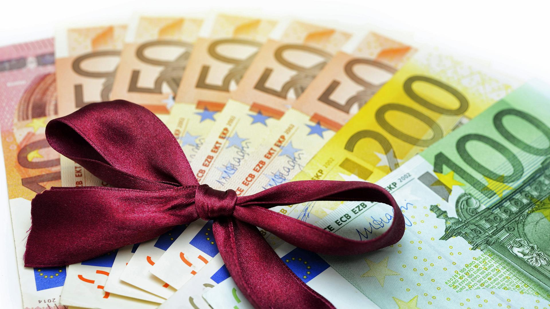560 Euro mit Geschenkschleife - Symboldbild: Bedingungsloses grundeinkommen 560 Euro mit Geschenkschleife - Symboldbild: Bedingungsloses grundeinkommen