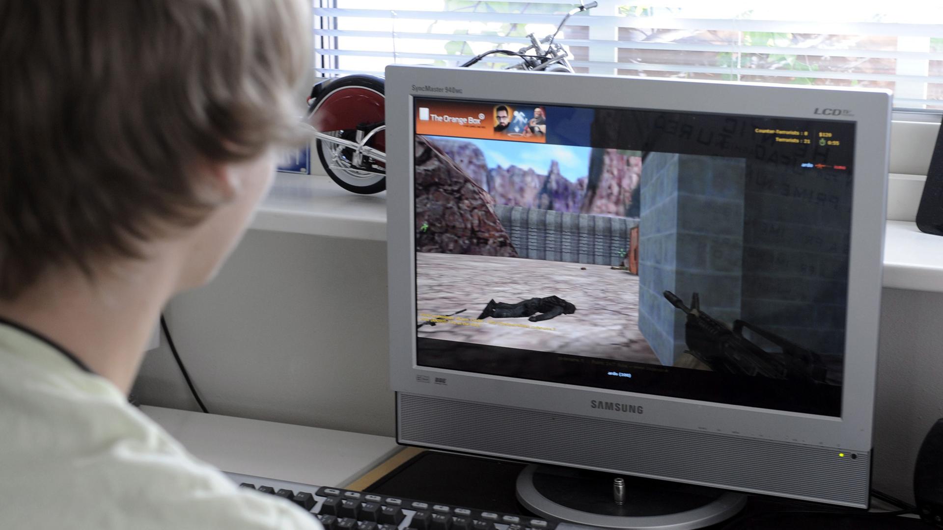 Ein junger Mann spielt einen klassischen Egoshooter. Ein junger Mann spielt einen klassischen Egoshooter.