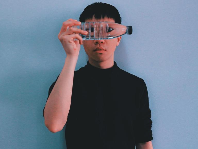 Das Bild zeigt einen Jungen, der eine durchsichtige Plastikflasche mit Wasser vor seine Augen hält. Das Bild zeigt einen Jungen, der eine durchsichtige Plastikflasche mit Wasser vor seine Augen hält.