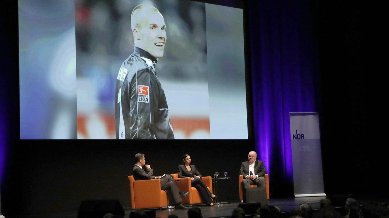 Bei einer Podiumsdiskussion im Theater am Aegi in Hannover anlässlich des 10. Todestages von Robert Enke sind der Moderator Andreas Kaeckell mit Teresa Enke und Uli Hoeness auf der Bühne zu sehen. Im Hintergrund wird ein Foto von Robert Enke im Hannover 96 Trikot gezeigt. Bei einer Podiumsdiskussion im Theater am Aegi in Hannover anlässlich des 10. Todestages von Robert Enke sind der Moderator Andreas Kaeckell mit Teresa Enke und Uli Hoeness auf der Bühne zu sehen. Im Hintergrund wird ein Foto von Robert Enke im Hannover 96 Trikot gezeigt.