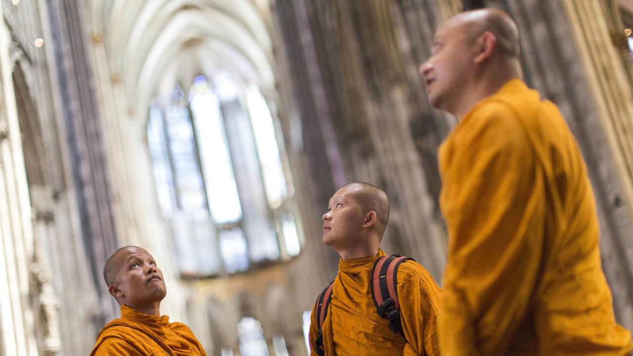 Buddhistische Mönche besichtigen den Kölner Dom.