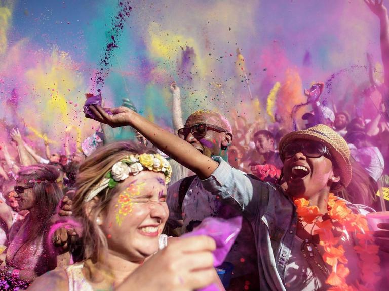 Menschen werfen beim Holi-Festival in Johannesbrug, Südafrika, mit Farben um sich. Das Festival soll vor allem Zusammenhalt und einen "bunten Alltag" fördern.