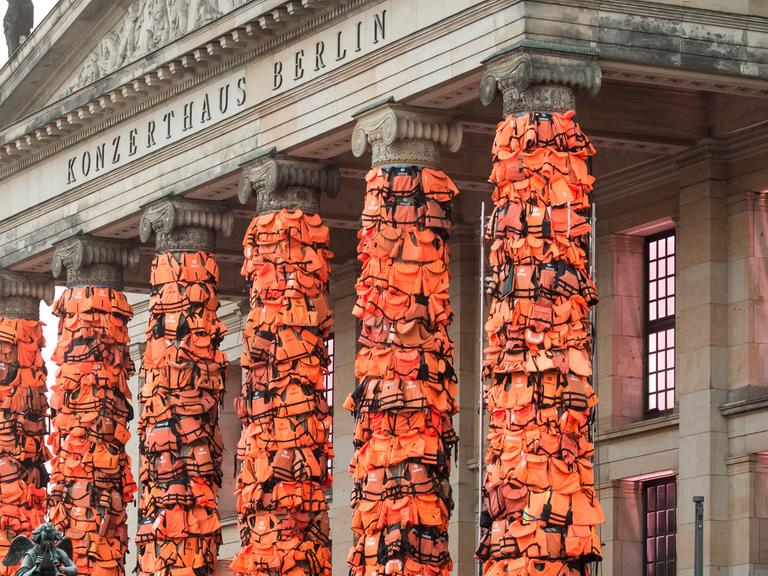 Arbeiter befestigen am 13.02.2016 am Konzerthaus am Gendarmenmarkt in Berlin zahlreiche Rettungswesten. Der chinesische Künstler Ai Weiwei will mit der Kunstinstallation an das Schicksal der vielen Flüchtlinge, die auf ihrem Weg nach Europa ertrunken sind, erinnern. Die Rettungswesten hatte er dazu von der griechischen Insel Lesbos bekommen
