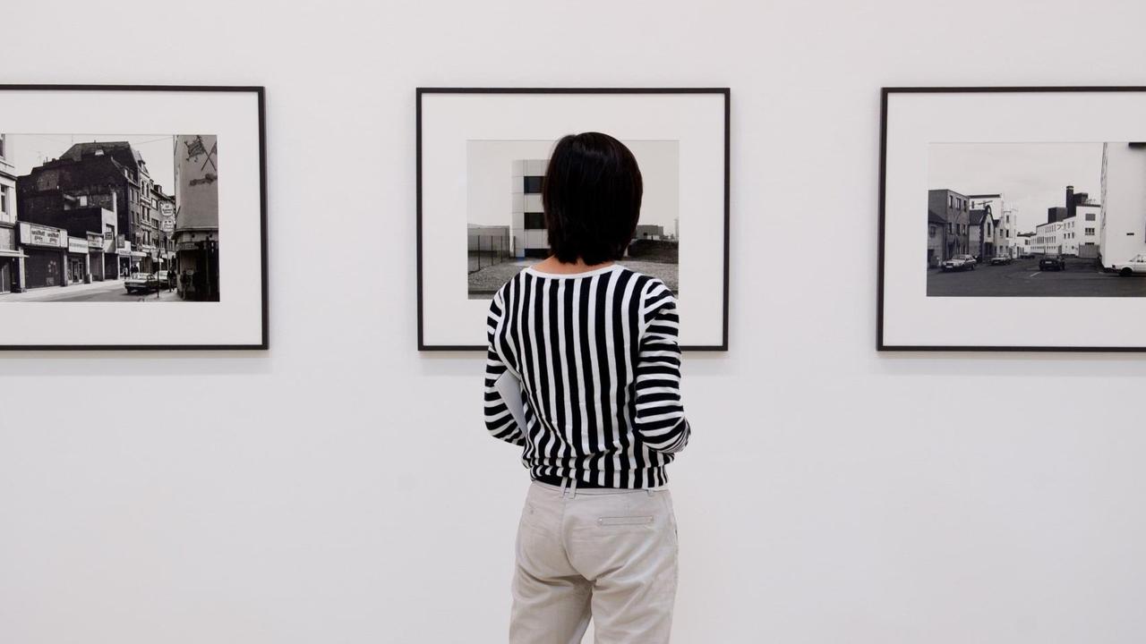 Eine Frau steht am 12.08.2013 in der Ausstellung «Wilhelm Schürmann. Bilder aus Deutschland» im Sprengel Museum in Hannover (Niedersachsen) vor den Fotografien "Eigelstein, 1989" (l-r), "Toyota, Köln, 1990" und "Köln, 1988" von Wilhelm Schürmann. Eine Frau steht am 12.08.2013 in der Ausstellung «Wilhelm Schürmann. Bilder aus Deutschland» im Sprengel Museum in Hannover (Niedersachsen) vor den Fotografien "Eigelstein, 1989" (l-r), "Toyota, Köln, 1990" und "Köln, 1988" von Wilhelm Schürmann.