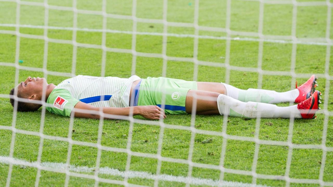 Ohis Felix Uduokhai liegt geschalgen auf dem Rasen nach dem Spiel gegen den Hamburger SV am 28.04.2018 in Wolfsburg. Ohis Felix Uduokhai liegt geschalgen auf dem Rasen nach dem Spiel gegen den Hamburger SV am 28.04.2018 in Wolfsburg.