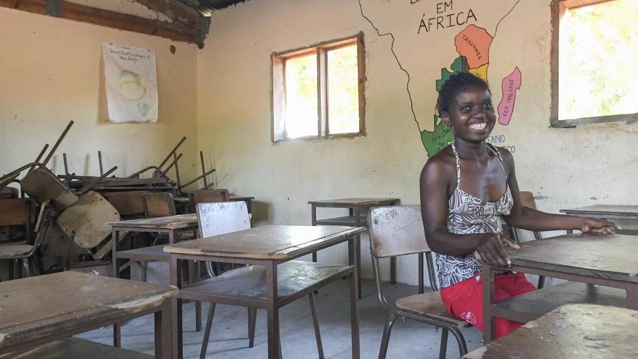 Die 26-jährige Lehrerin Anifa Armando Cao sitzt auf deiner Schulbank in der Grundschule in Chai-Chai. An der Wand hinter ihr ist eine Afrika-Karte. Die 26-jährige Lehrerin Anifa Armando Cao sitzt auf deiner Schulbank in der Grundschule in Chai-Chai. An der Wand hinter ihr ist eine Afrika-Karte.