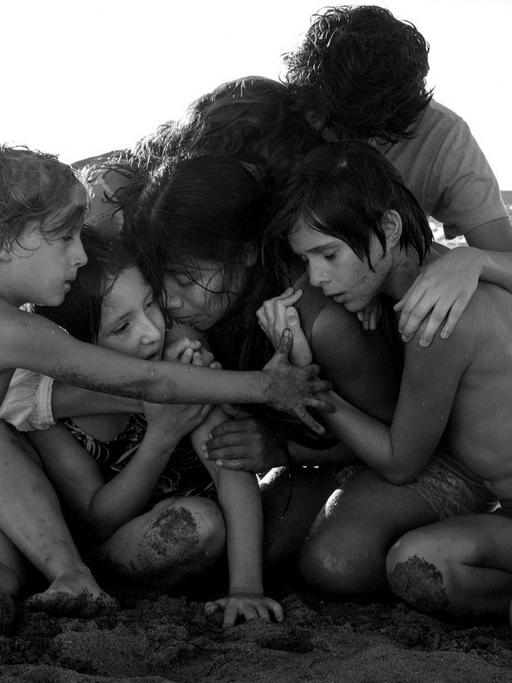 Filmszene aus Cuaróns "Roma": Die jugendlichen Hauptdarsteller kauern am Strand und umarmen sich.