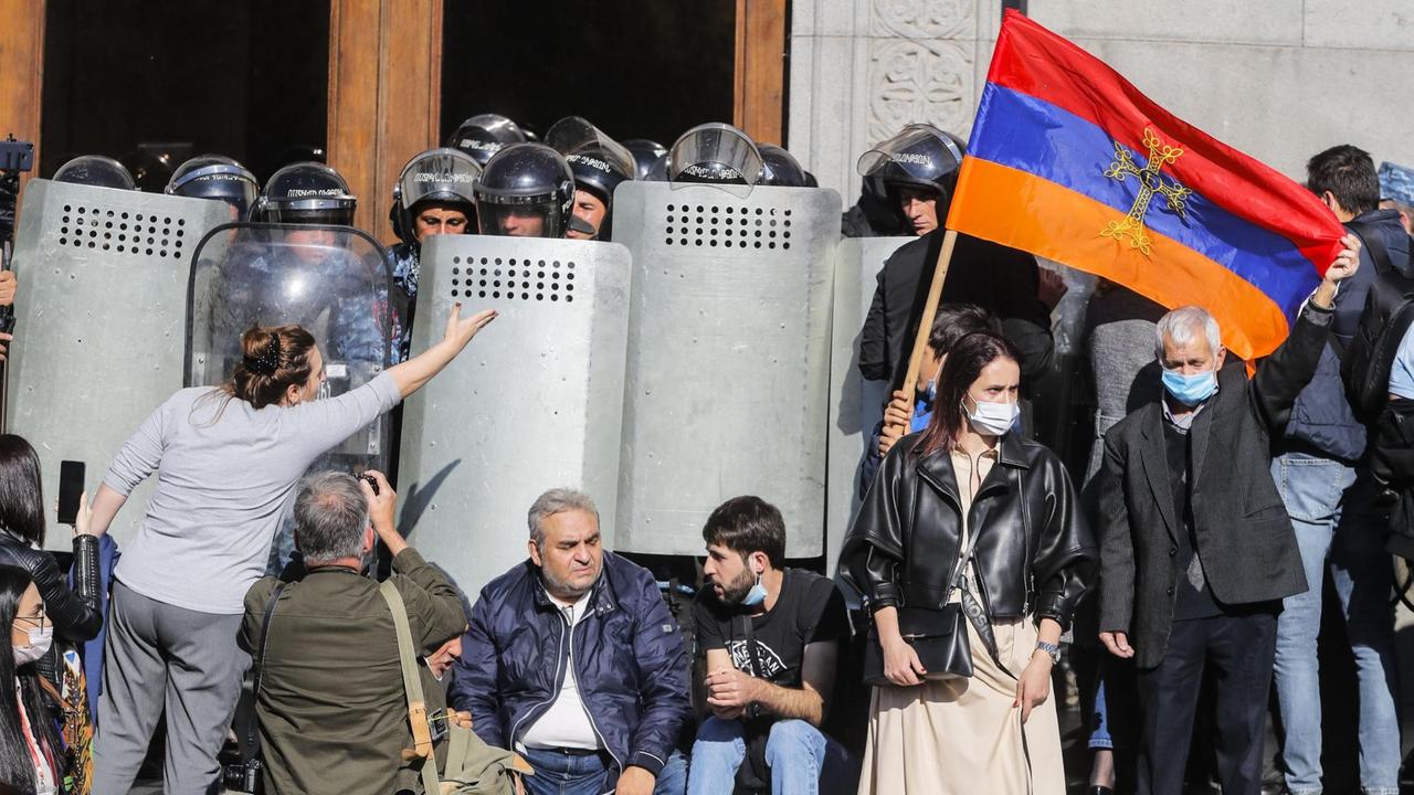 Demonstranten heben vor der Polizei die armenische Nationalflagge hoch im Rahmen der Proteste gegen eine Vereinbarung zur Einstellung der Kämpfe um die Region Bergkarabach.