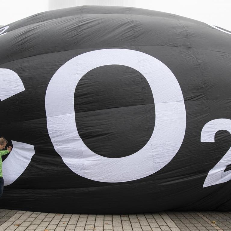 Frankfurt/Main: Aktivisten von Greenpeace füllen vor der Messe IAA einen riesigen Ballon mit Luft. Auf dem Ballon steht "CO2". 