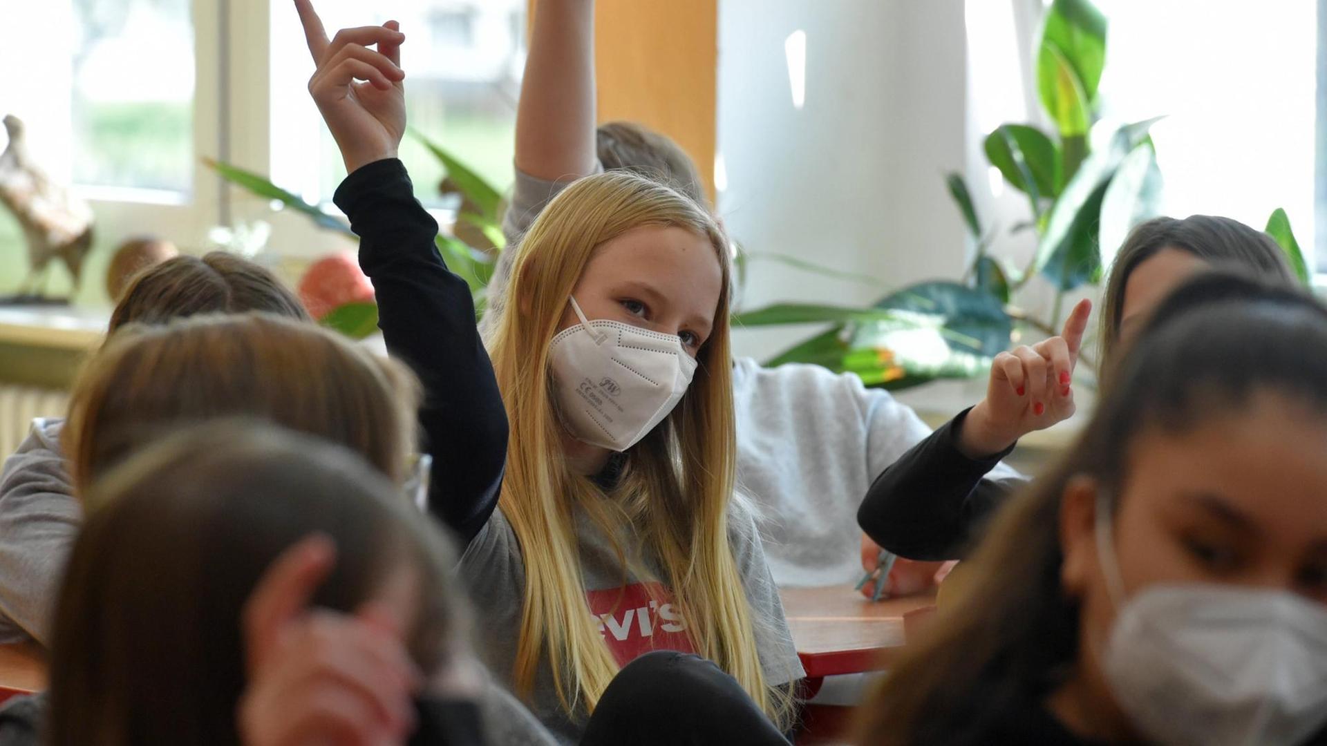 Kinder in Schulklasse mit Maske während der Corona-Pandemie