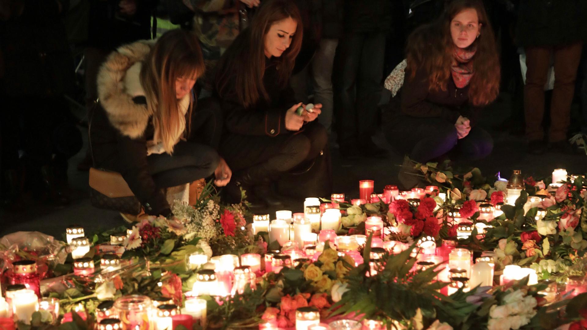 Passanten legen vor der Gedächtniskirche in Berlin zum Gedenken an die Opfer des Anschlags Kerzen und Blumen nieder. Passanten legen vor der Gedächtniskirche in Berlin zum Gedenken an die Opfer des Anschlags Kerzen und Blumen nieder.