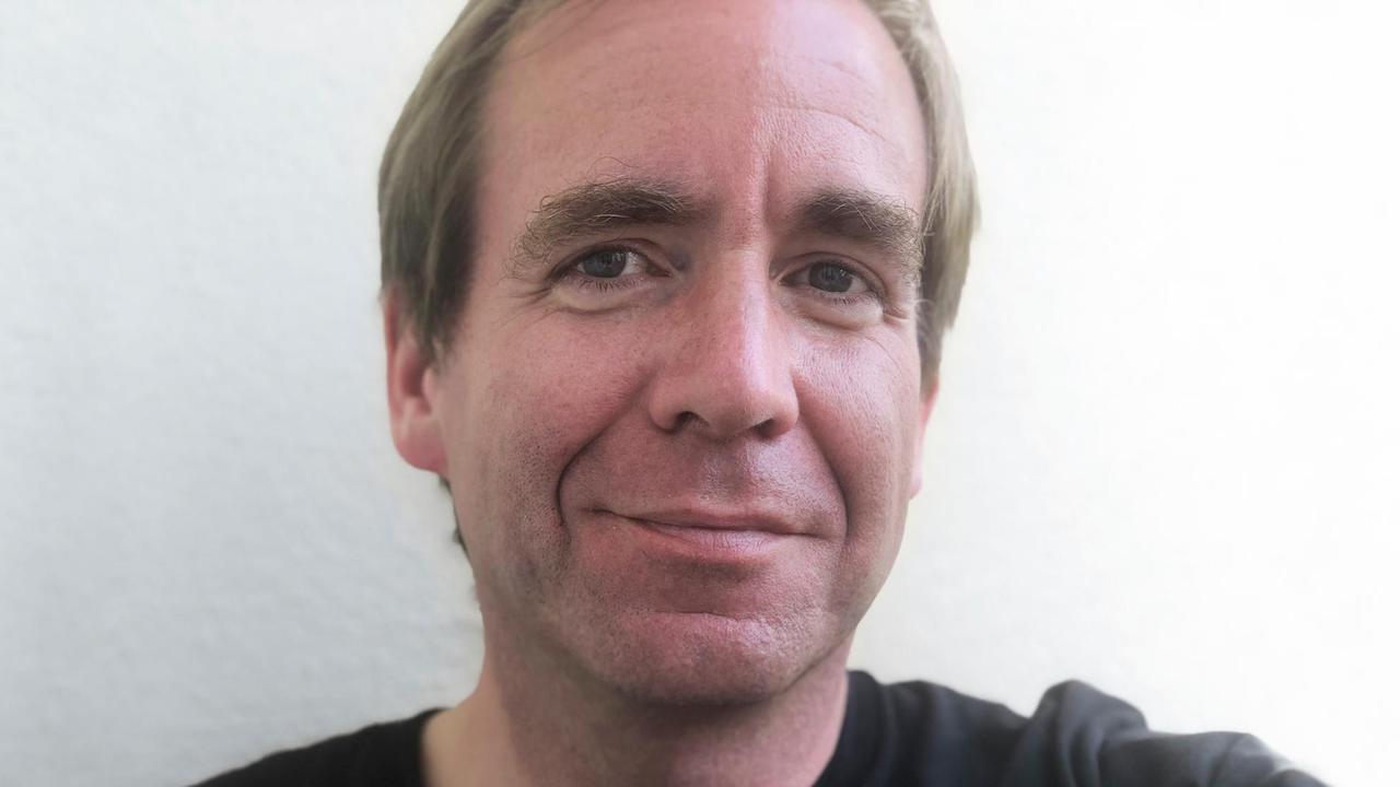 Porträt von Stefan Kuzmany vor einem weissen Hintergrund Porträt von Stefan Kuzmany vor einem weissen Hintergrund