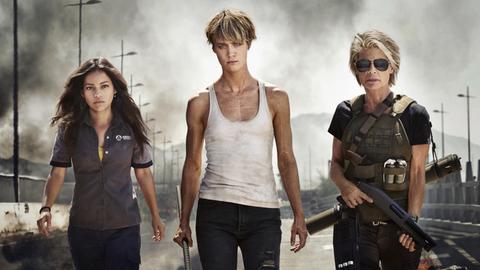 Das Bild zeigt drei kämpferisch schauende Frauen mit Waffen aus dem Film "Terminator: Dark Fate"