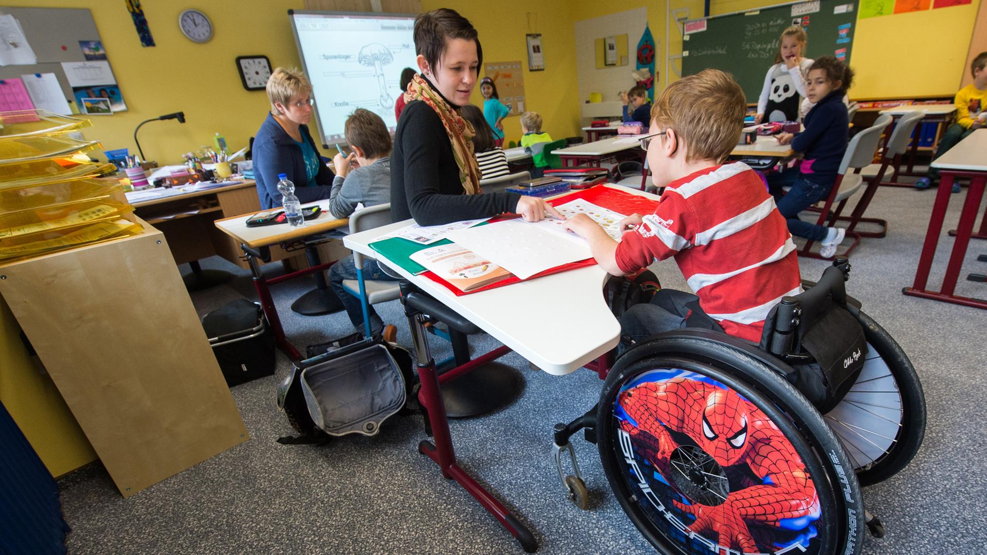 In einer Grundschul-Klasse sitzt ein Junge im Rollstuhl. In einer Grundschul-Klasse sitzt ein Junge im Rollstuhl.
