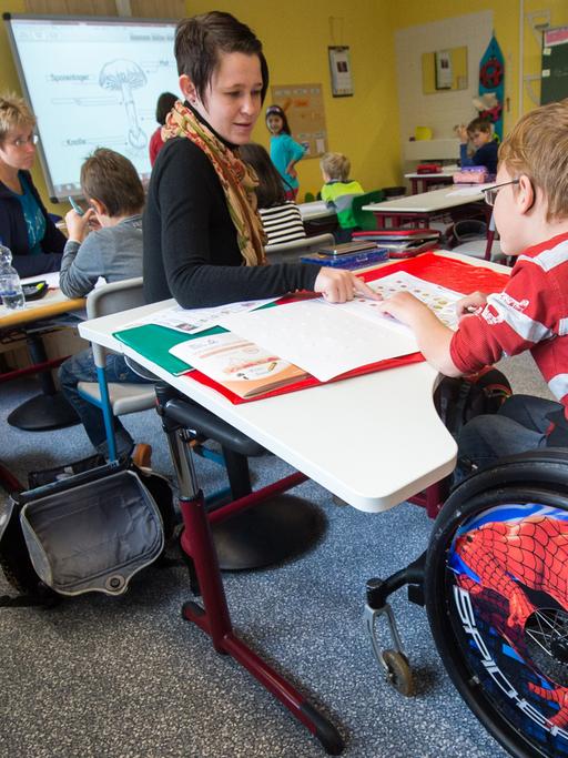 In einer Grundschul-Klasse sitzt ein Junge im Rollstuhl.