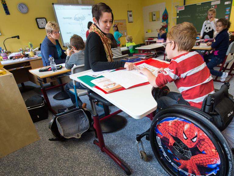 In einer Grundschul-Klasse sitzt ein Junge im Rollstuhl