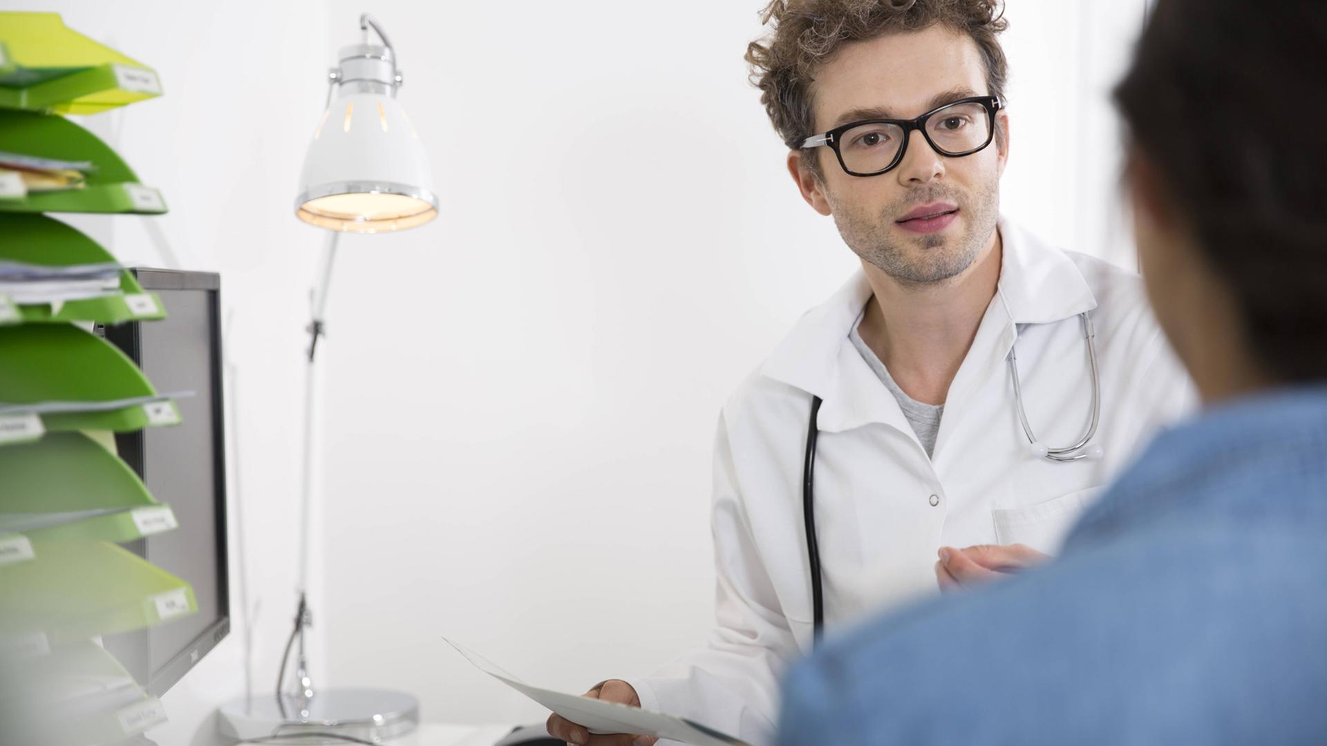Ein Arzt im Gespräch mit einer Patientin. Ein Arzt im Gespräch mit einer Patientin.