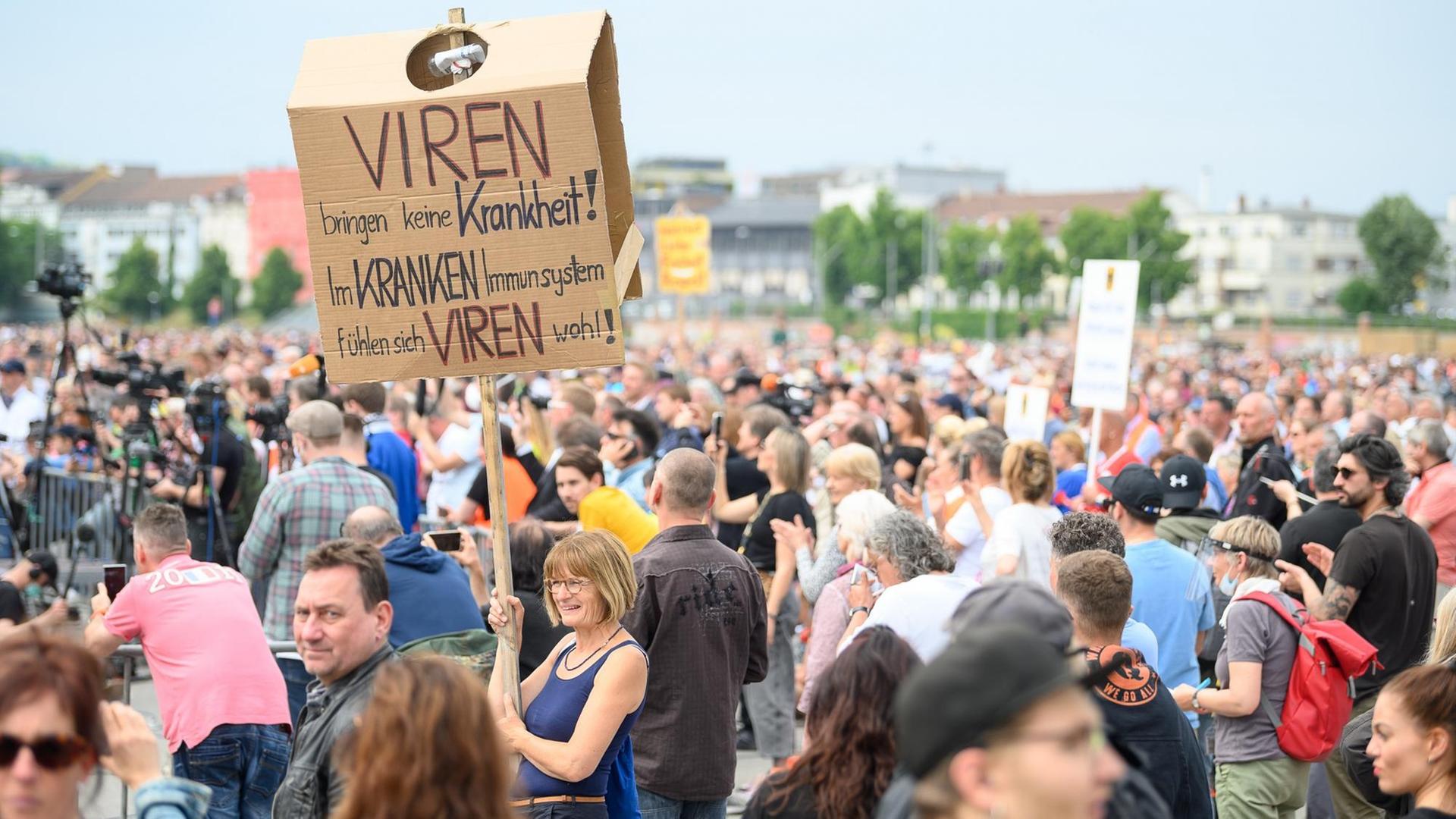 Eine Frau hält während einer Protestkundgebung ein Schild mit der Aufschrift "Viren bringen keine Krankheit! Im kranken Immunsystem fühlen sich Viren wohl!" Eine Frau hält während einer Protestkundgebung ein Schild mit der Aufschrift "Viren bringen keine Krankheit! Im kranken Immunsystem fühlen sich Viren wohl!"