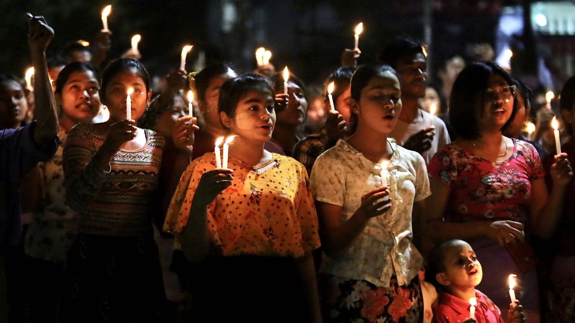 Auf dem Foto sind junge Menschen zu sehen, die im Rahmen der Proteste gegen die Militärregierung in Myanmar, nachts Kerzen hochhalten. Auf dem Foto sind junge Menschen zu sehen, die im Rahmen der Proteste gegen die Militärregierung in Myanmar, nachts Kerzen hochhalten.