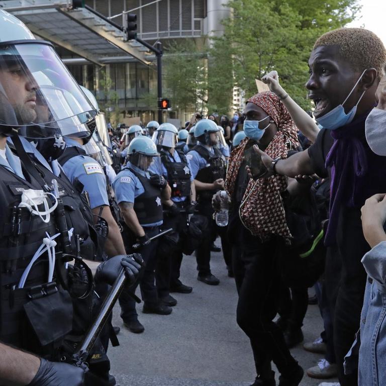 Mehrere Teilnehmer einer Demonstration stehen in Chicago einer Gruppe von Polizisten gegenüber