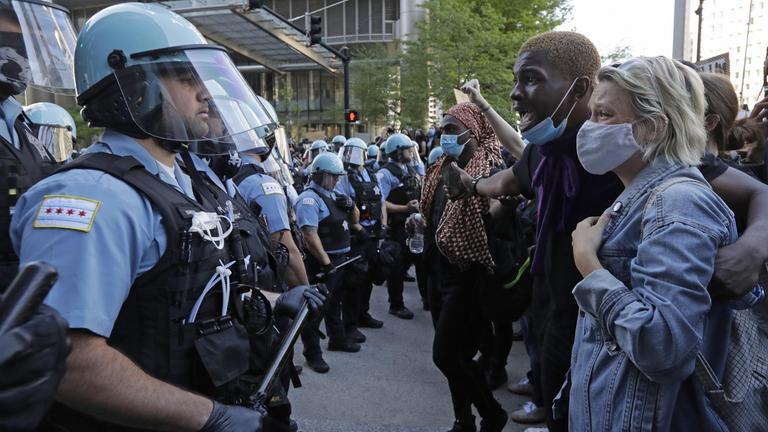 Mehrere Teilnehmer einer Demonstration stehen in Chicago einer Gruppe von Polizisten gegenüber