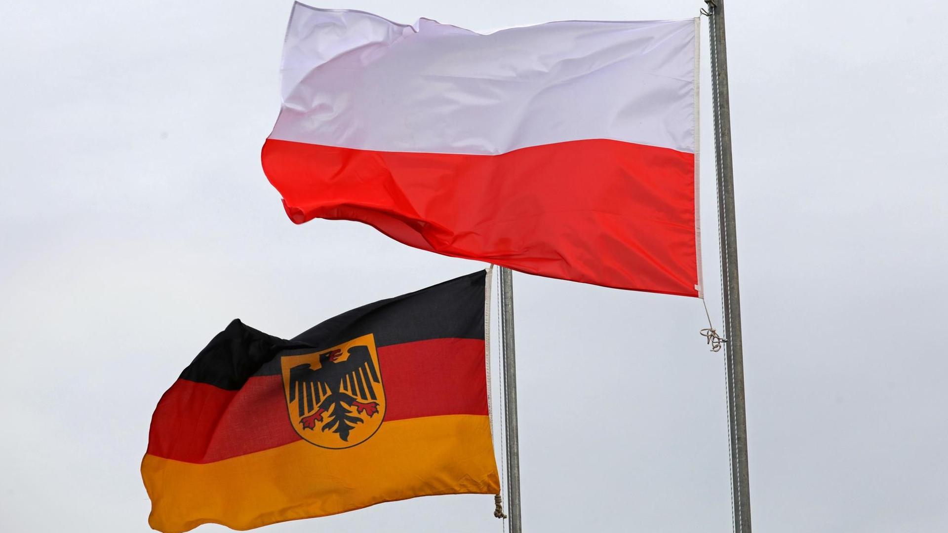 Eine deutsche und eine polnische Fahne wehen nebeneinander Eine deutsche und eine polnische Fahne wehen nebeneinander