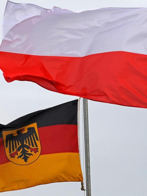 Eine deutsche und eine polnische Fahne wehen nebeneinander