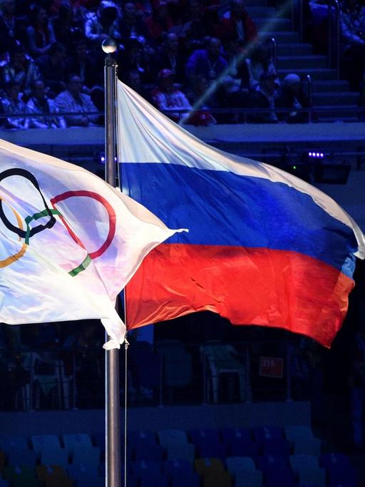 Die olympische und die russische Flagge nebeneinander bei den Winterspielen in Sotschi 2014.