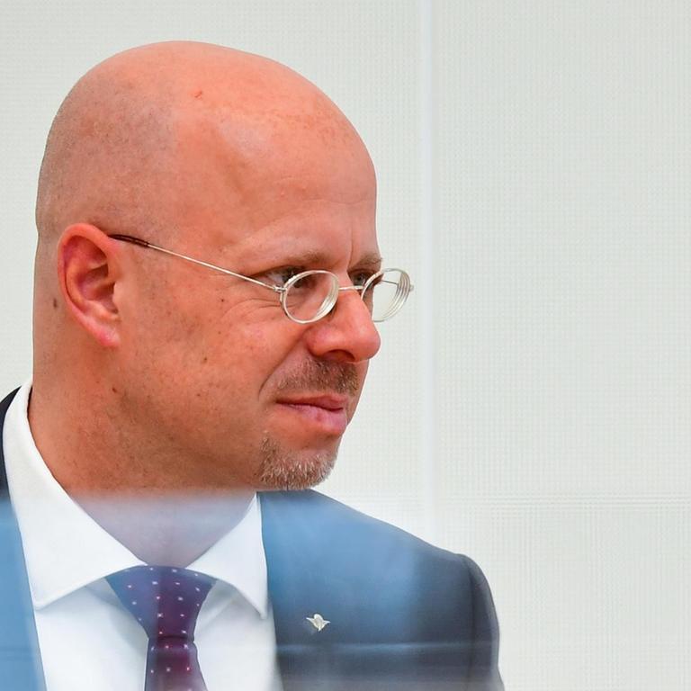 Porträtaufnahme des AfD-Politikers Andreas Kalbitz im Landtag, teilweise hinter einer Plexiglasscheibe.