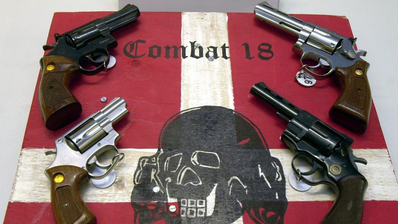 Sichergestellte Waffen und ein Schild der kriminellen Neonazi-Gruppe "Combat 18" liegen am 28.10.2003 im schleswig-holsteinischen Landeskriminalamt (LKA) in Kiel. Im Zuge einer groß angelegten Aktion hat die Polizei die Gruppierung "Combat 18" in Norddeutschland zerschlagen. Nach LKA-Angaben durchsuchten rund 300 Beamte am Morgen des 28.10. gut 50 Wohnungen und Treffpunkte. Sichergestellte Waffen und ein Schild der kriminellen Neonazi-Gruppe "Combat 18" liegen am 28.10.2003 im schleswig-holsteinischen Landeskriminalamt (LKA) in Kiel. Im Zuge einer groß angelegten Aktion hat die Polizei die Gruppierung "Combat 18" in Norddeutschland zerschlagen. Nach LKA-Angaben durchsuchten rund 300 Beamte am Morgen des 28.10. gut 50 Wohnungen und Treffpunkte.