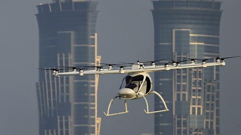 Ein Volocopter Prototyp fliegt am 26.9.2017 in Dubai, im Hintergrund zwei Wolkenkratzer.