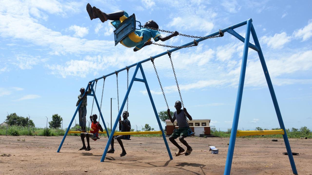 Kinder spielen am 28.06.2017 auf einem Spielplatz in der Flüchtlingssiedlung Bidi Bidi im Nordwesten von Uganda. Auch Spielplätze gibt es in den Flüchtlingssiedlungen. ACHTUNG Honorarfrei nur für Bezieher des Dienstes dpa-Nachrichten für Kinder. Foto: Gioia Forster/dpa | Verwendung weltweit