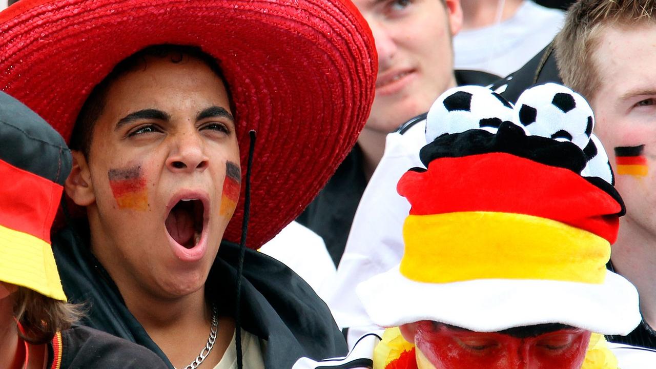 Sichtlich gelangweilt verfolgen Fußballfans am Freitag (18.06.2010) auf der Fanmeile vor dem Olympiastadion in Berlin die Niederlage der deutschen Elf bei derFußball-WM in Südafrika. Sichtlich gelangweilt verfolgen Fußballfans am Freitag (18.06.2010) auf der Fanmeile vor dem Olympiastadion in Berlin die Niederlage der deutschen Elf bei derFußball-WM in Südafrika.