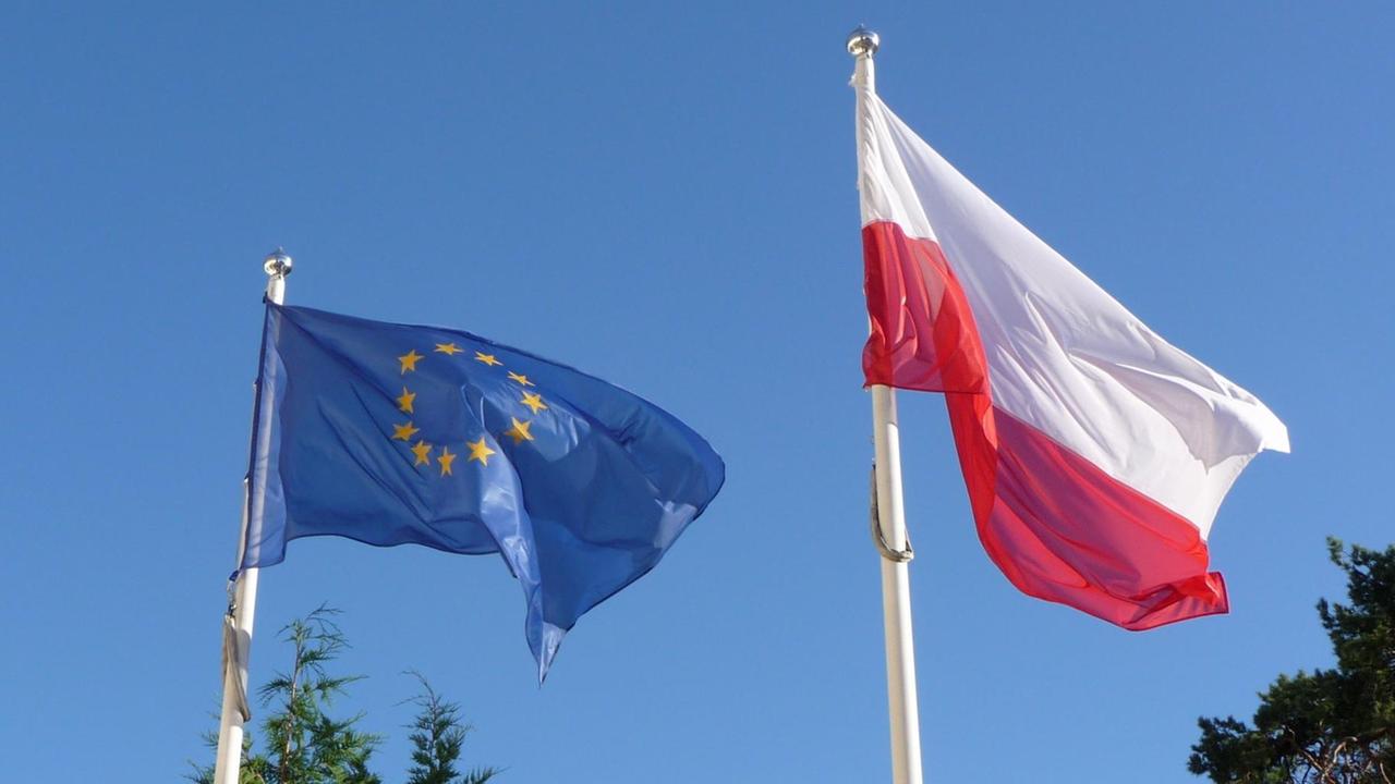 Eine polnische Flagge und eine Europafahne wehen im Wind. Eine polnische Flagge und eine Europafahne wehen im Wind.