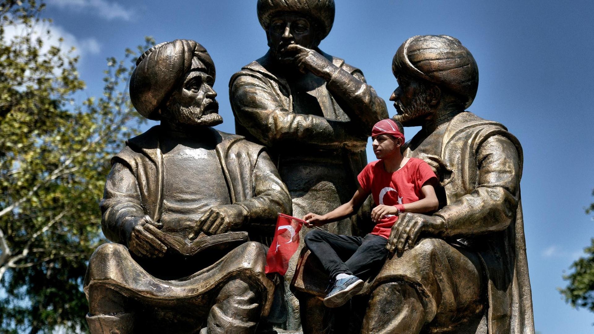 Ein junger Mann sitzt auf einer Statue für Sultan Mehmed II im Sarachane-Park von Istanbul während einer Demonstration für den türkischen Präsidenten Erdogan am 19.7.2016. Ein junger Mann sitzt auf einer Statue für Sultan Mehmed II im Sarachane-Park von Istanbul während einer Demonstration für den türkischen Präsidenten Erdogan am 19.7.2016.