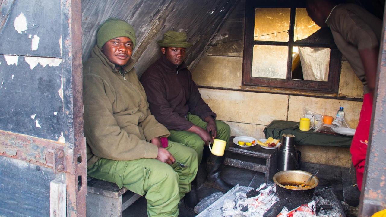 Wildhüter trinken Kaffee in einer Hütte auf dem Vulkan Nyiragongo Wildhüter trinken Kaffee in einer Hütte auf dem Vulkan Nyiragongo
