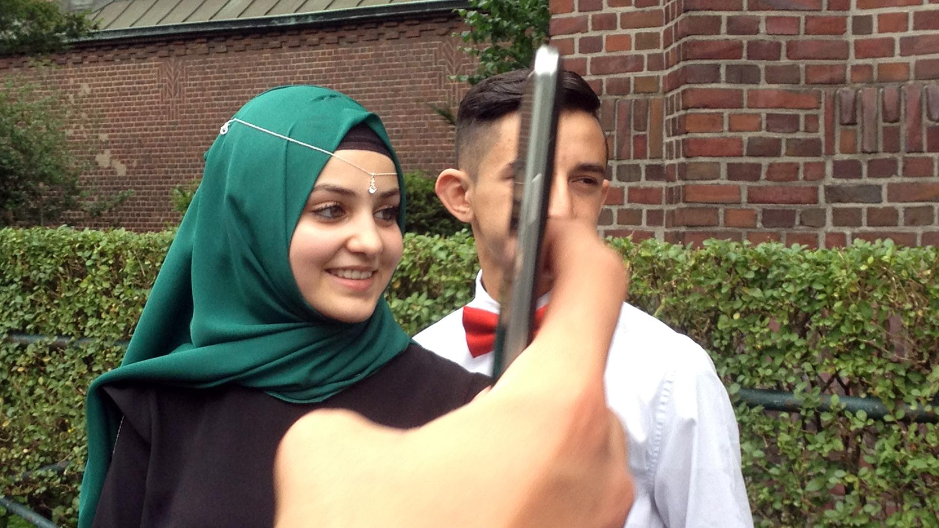 Die Schülerin Ümmi mit grünem Kopftuch und -schmuck bei der Abschlussfeier Die Schülerin Ümmi mit grünem Kopftuch und -schmuck bei der Abschlussfeier
