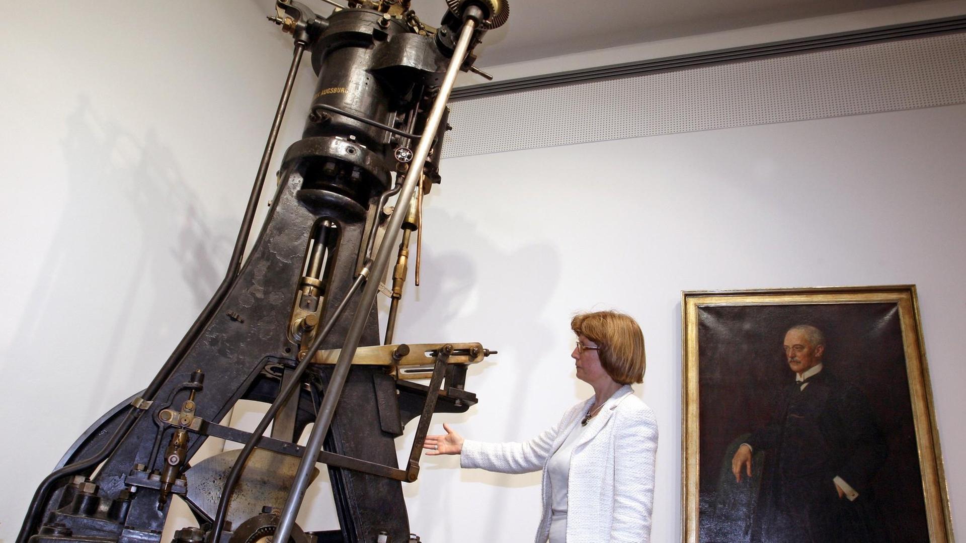 Eine Frau betrachtet am Mittwoch (12.03.2008) im MAN-Museum Augsburg (Schwaben) den ersten Versuchsdieselmotor, den Rudolf Diesel in den Jahren 1893 bis 1895 erbaute. Vor 150 Jahren, am 18.März 1858, wurde Rudolf Diesel als Sohn deutscher Eltern in Paris geboren. In Augsburg verwirklichte er seine Idee einer "neuen rationellen Wärmekraftmaschine" in Zusammenarbeit mit der Maschinenfabrik Augsburg, einer Vorgängerfirma der heutigen MAN-Gruppe. Foto: Karl-Josef Hildenbrand dpa/lby (zu dpa-KORR vom 13.03.2008: "Rudolf Diesel - Genialer Erfinder und begnadeter Ingenieur") +++(c) dpa - Report+++ | Verwendung weltweit Eine Frau betrachtet am Mittwoch (12.03.2008) im MAN-Museum Augsburg (Schwaben) den ersten Versuchsdieselmotor, den Rudolf Diesel in den Jahren 1893 bis 1895 erbaute. Vor 150 Jahren, am 18.März 1858, wurde Rudolf Diesel als Sohn deutscher Eltern in Paris geboren. In Augsburg verwirklichte er seine Idee einer "neuen rationellen Wärmekraftmaschine" in Zusammenarbeit mit der Maschinenfabrik Augsburg, einer Vorgängerfirma der heutigen MAN-Gruppe. Foto: Karl-Josef Hildenbrand dpa/lby (zu dpa-KORR vom 13.03.2008: "Rudolf Diesel - Genialer Erfinder und begnadeter Ingenieur") +++(c) dpa - Report+++ | Verwendung weltweit
