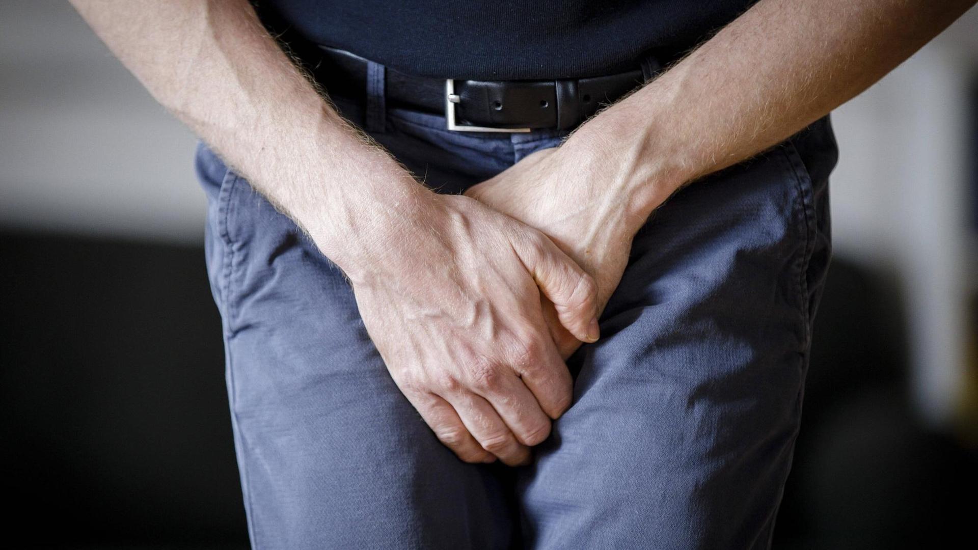 Ein Mann fasst sich mit seinen Händen in den Schritt. (Symbolfoto) Ein Mann fasst sich mit seinen Händen in den Schritt. (Symbolfoto)