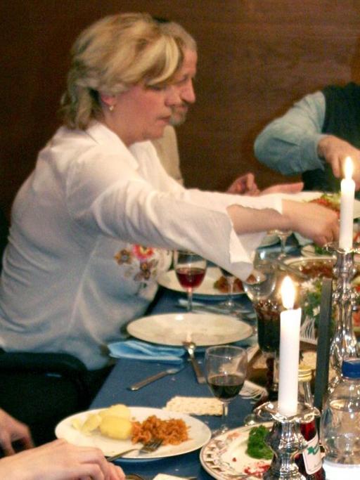 Eine jüdische Gemeinde beim Essen der symbolischen Pessach-Speisen während des Sederabends, dem Abend vor dem Pessach-Fest