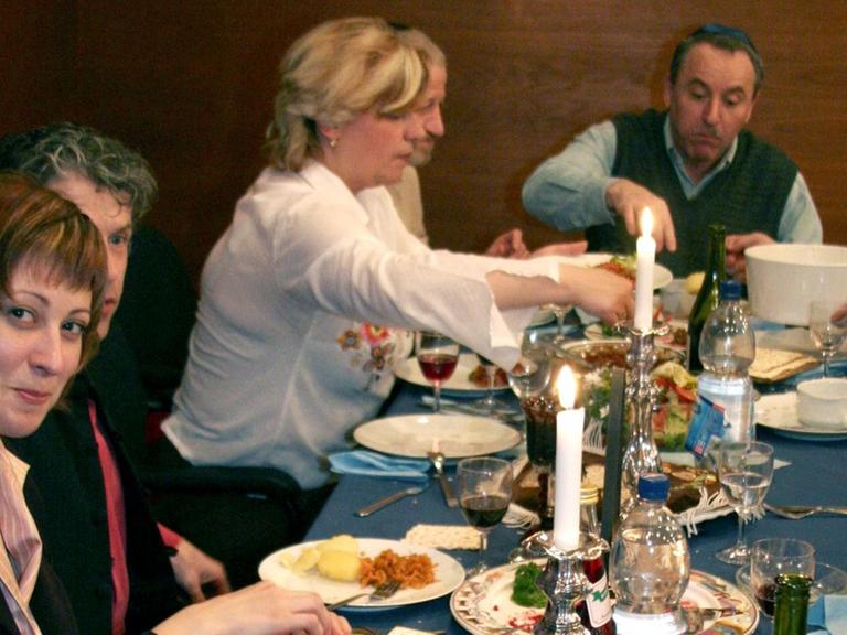 Eine jüdische Gemeinde beim Essen der symbolischen Pessach-Speisen während des Sederabends, dem Abend vor dem Pessach-Fest