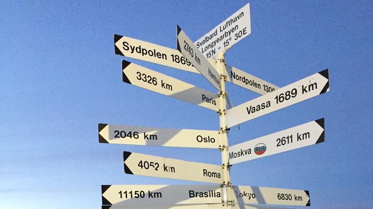 Hoch im Norden und doch noch 1300 Kilometer bis zum Nordpol: Entfernungsschilder auf dem Flughafen von Spitzbergen Hoch im Norden und doch noch 1300 Kilometer bis zum Nordpol: Entfernungsschilder auf dem Flughafen von Spitzbergen
