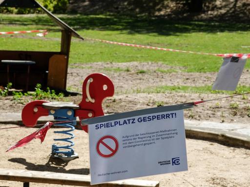 Absperrbänder und ein Schild "Spielplatz gesperrt" sind an einem Spielplatz in Charlottenburg angebracht.