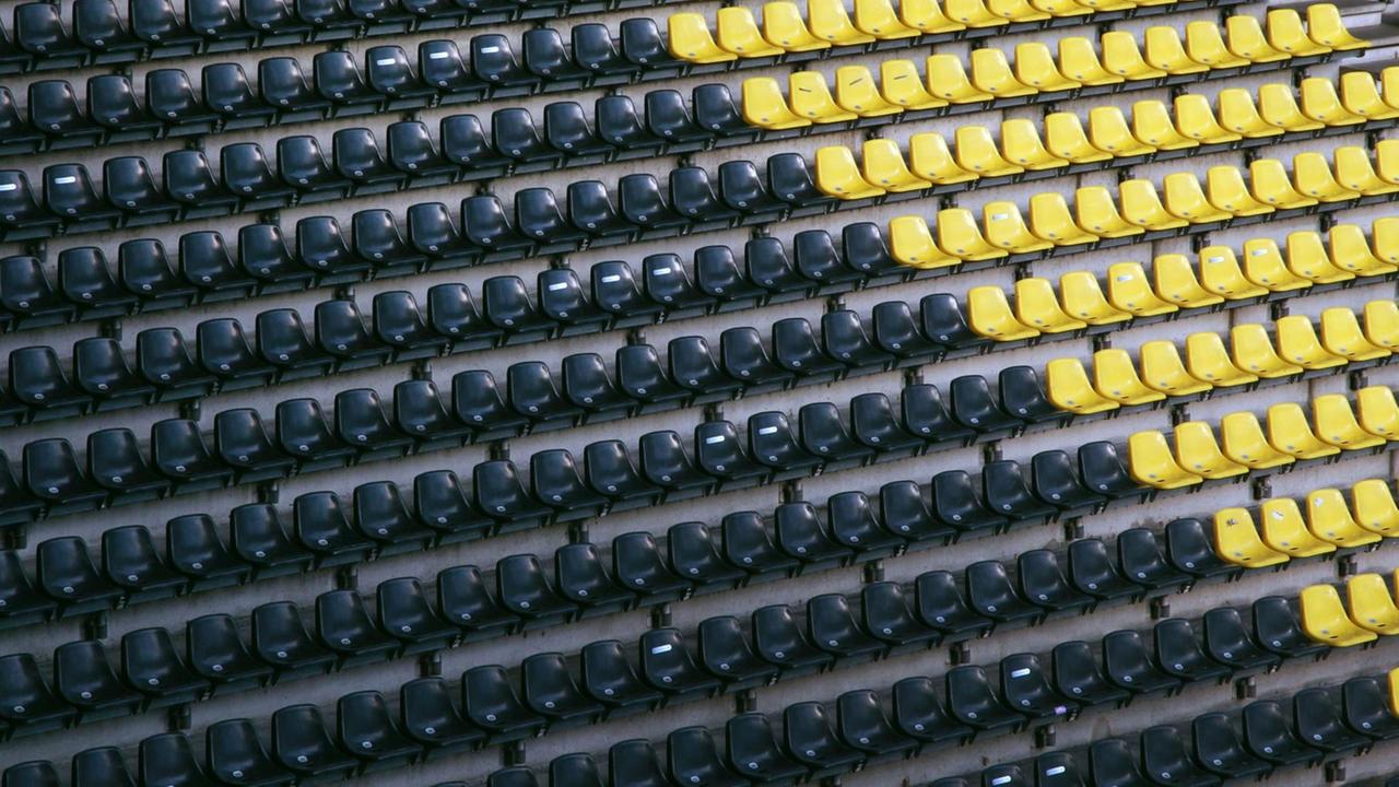 Ein Fan sitzt auf der leeren Tribüne im Dortmunder Fußballstadion. Ein Fan sitzt auf der leeren Tribüne im Dortmunder Fußballstadion.