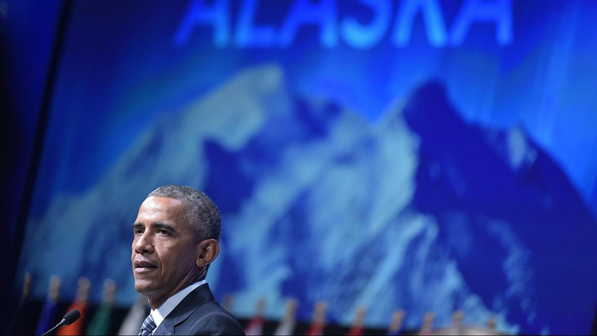 US-Präsident Barack Obama spricht vor einer blauen Wand, auf der Berggipfel zu sehen sind.