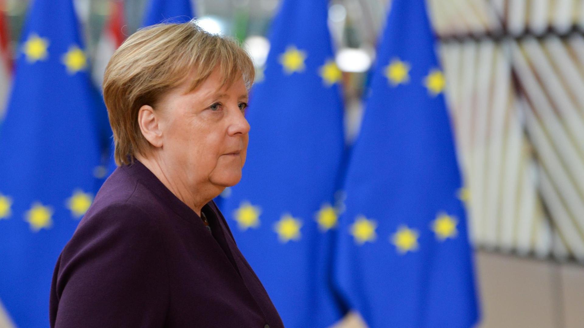 Bundeskanzlerin Merkel steht vor mehreren EU-Flaggen. Bundeskanzlerin Merkel steht vor mehreren EU-Flaggen.